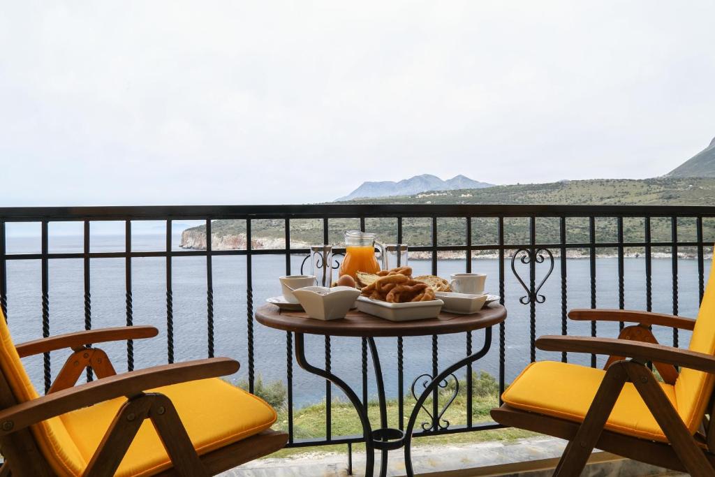 Πρωινό σε τραπεζάκι στο μπαλκόνι, με τη θάλασσα και τα βουνά της Μάνης στο βάθος