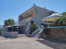 Η πέτρινη πρόσοψη του Panorama Rooms στον Διρό, με την ταβέρνα στο ισόγειο